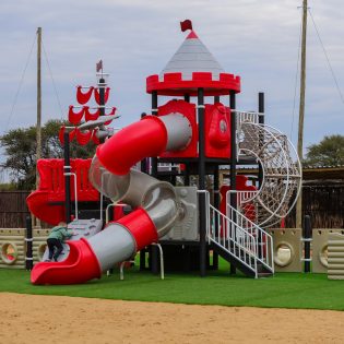 Nelo's Farmyard and Adventure located in Kimberley displaying a red and grey pirate ship jungle gym for kids 2-14 years old
